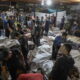 Foto konferensi pers yang beredar memperlihatkan para anggota staf medis berdiri di antara jasad-jasad yang ditutupi. (Foto Istimewa)